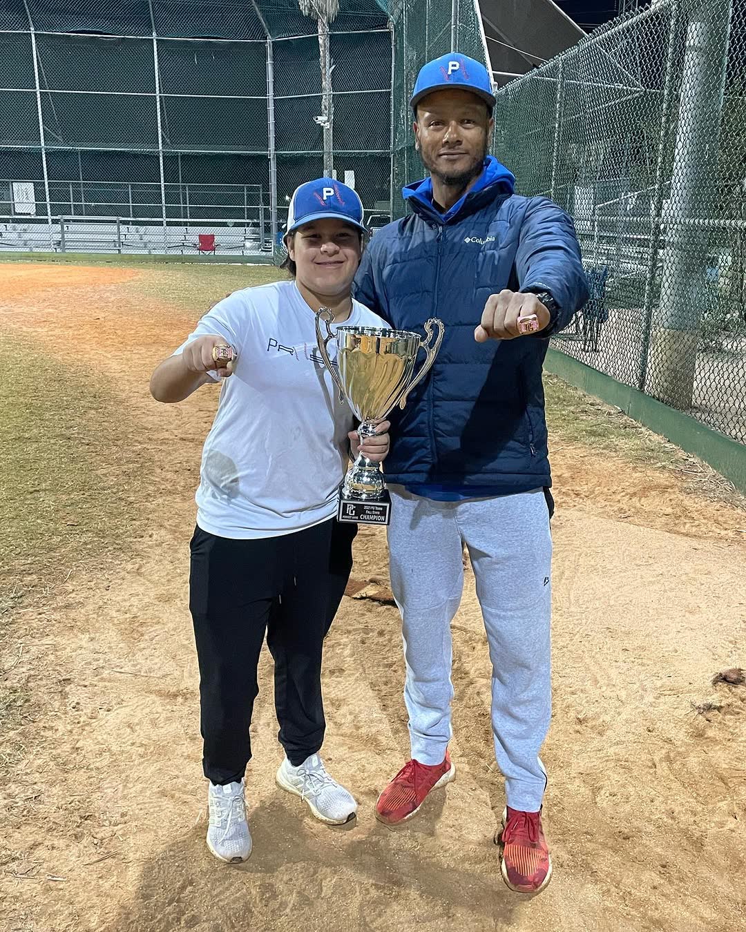 Coach C and player with championship trophy and rings